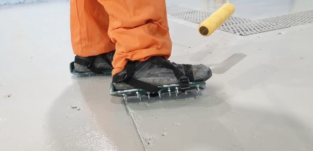 A man doing warehouse epoxy flooring coat